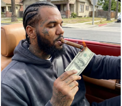 American Rapper The Game sets $100 bill on fire to prove he’s “never in love with money”