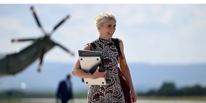 Trump’s assistant photographed juggling FOUR phones and two laptops getting off the plane
